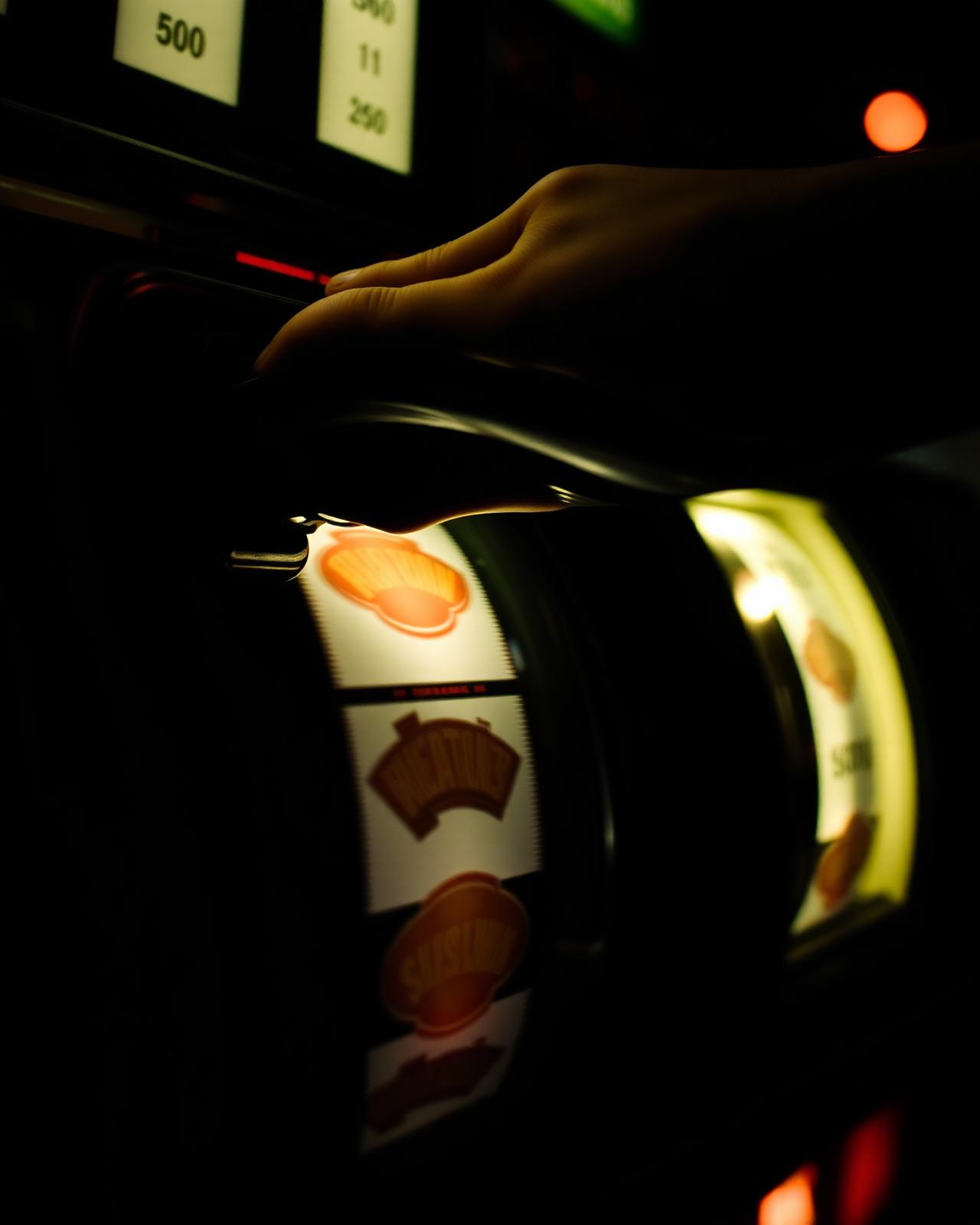 A hand resting on a vintage slot-machine lever.